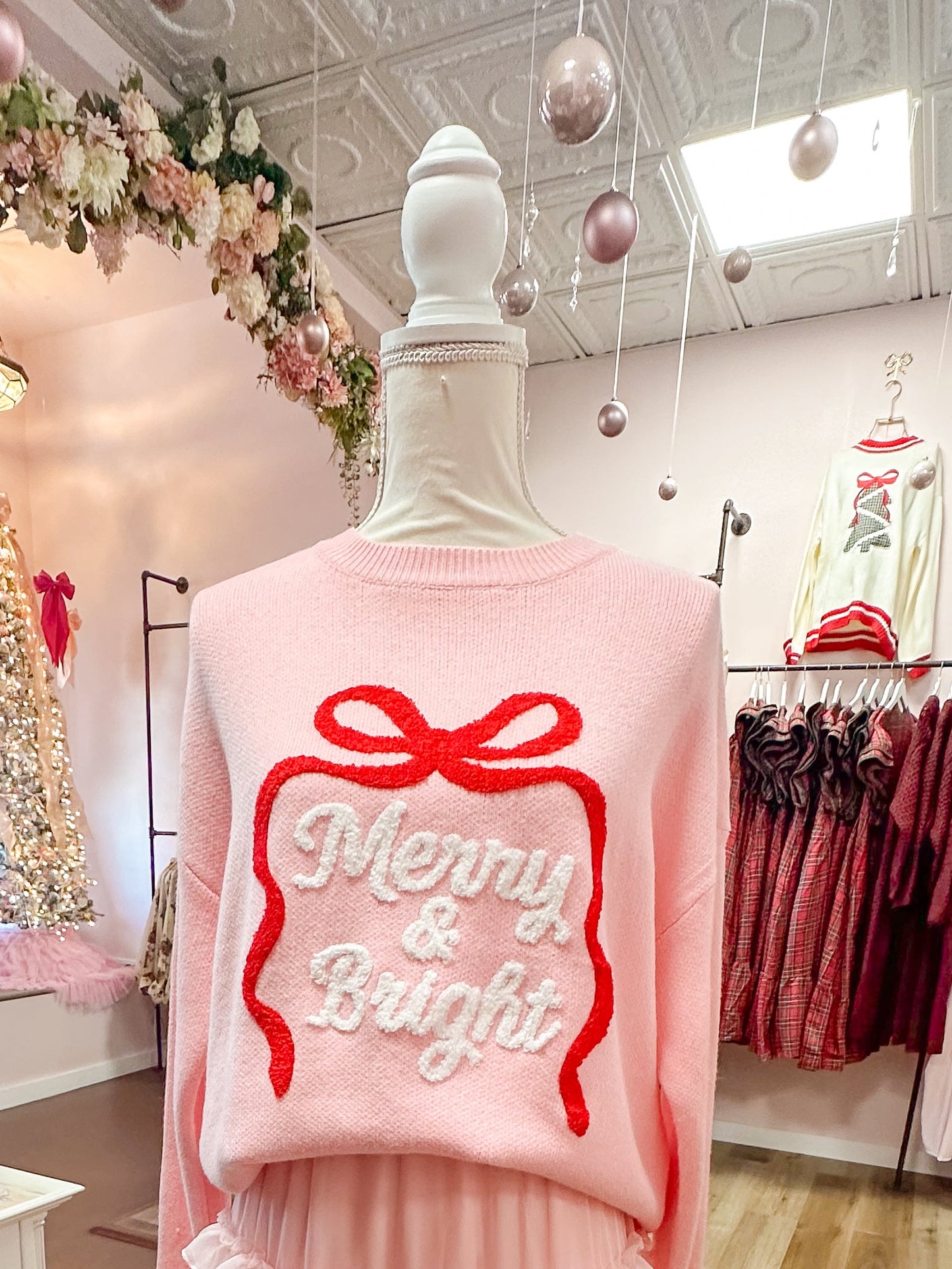 Pink outfit with a bow design on a mannequin in a store setting.