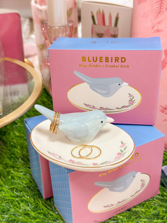 Bluebird ring holder and trinket dish with packaging on a grass-like surface