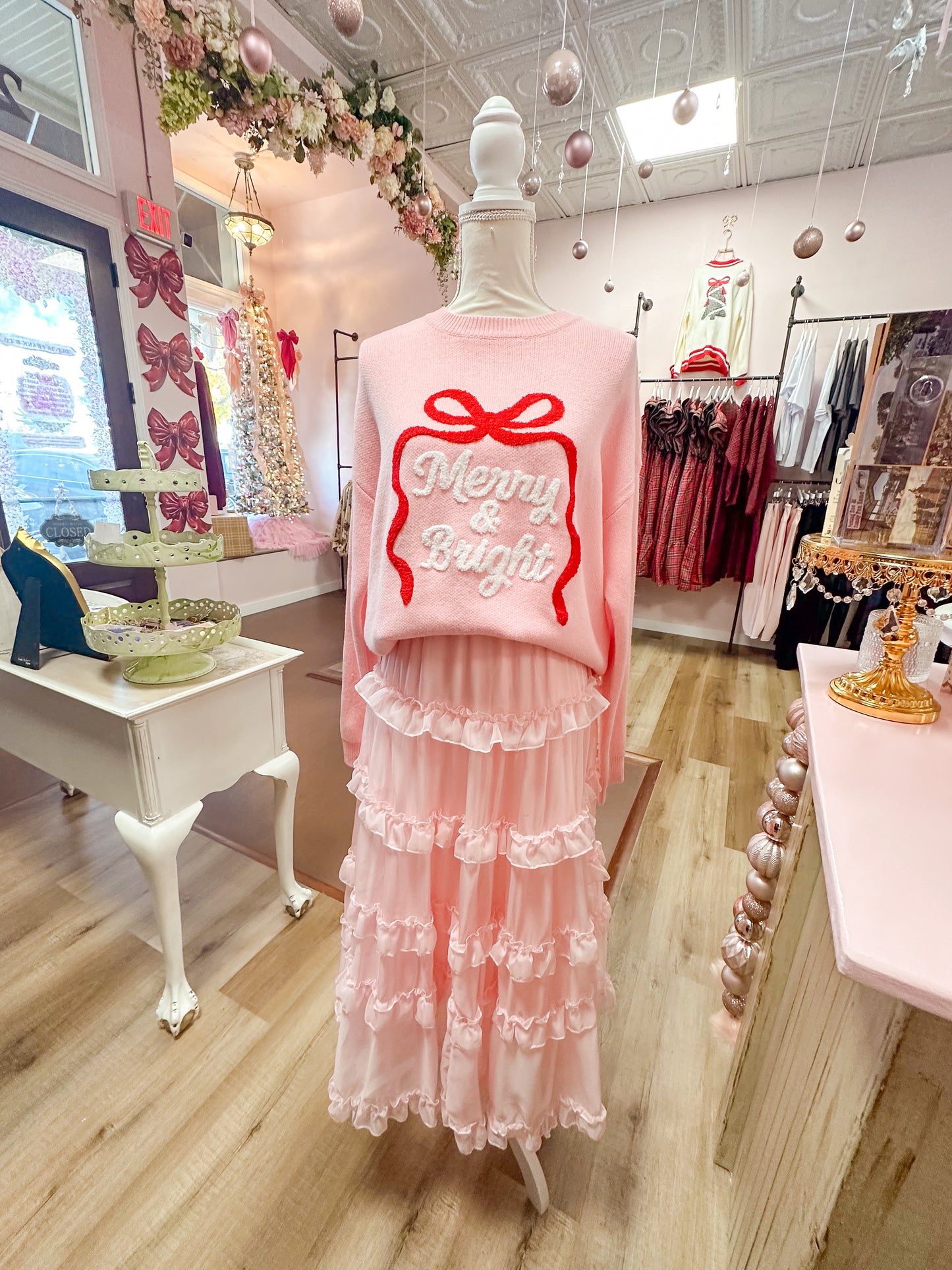 Pink outfit with a bow design on a mannequin in a store setting.