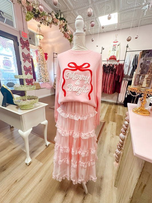 Pink outfit with a bow design on a mannequin in a store setting.